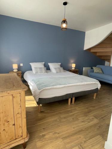 une chambre avec un lit et un mur bleu dans l'établissement Plein centre Auray - Grand duplex 2 chambres avec terrasse ensoleillée, à Auray