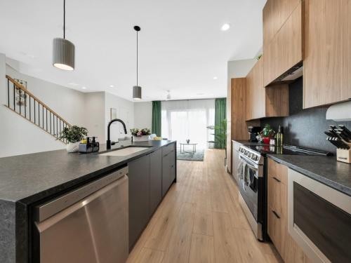 a large kitchen with black counters and wooden cabinets at Uptown Escape l Stylish Stay near Downtown Dallas in Dallas