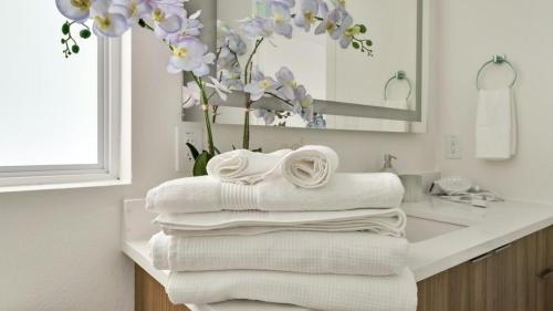 a pile of towels on a bathroom counter with a sink at Uptown Escape l Stylish Stay near Downtown Dallas in Dallas