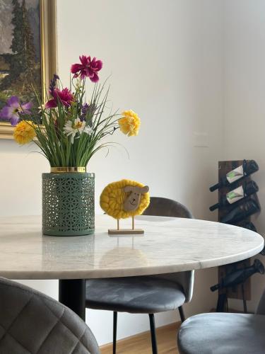 a table with a vase with flowers on top of it at Apartma 21 - Ajda in Bovec
