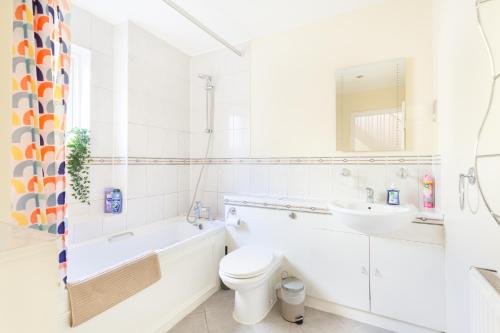 a white bathroom with a toilet and a sink at Tower Bridge Home in London