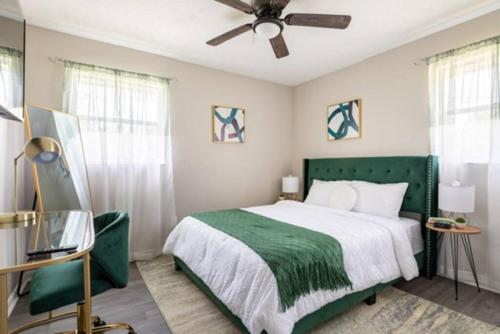 a bedroom with a green bed and a ceiling fan at UnWind Bungalow for 6 in Jacksonville