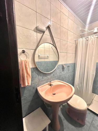 a bathroom with a sink and a mirror and a toilet at Casa da Lagoa in Tramandaí