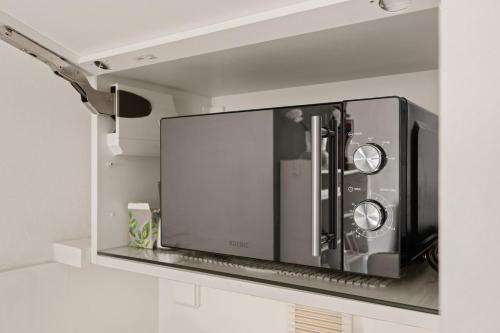 a microwave oven hanging on a wall in a kitchen at Smart City Apartment in Bestlage! self check-in, Neu! in Cologne