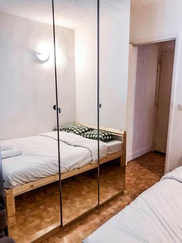 - une chambre avec 2 lits et un mur en verre dans l'établissement Charmant appartement à Puteaux, à Puteaux