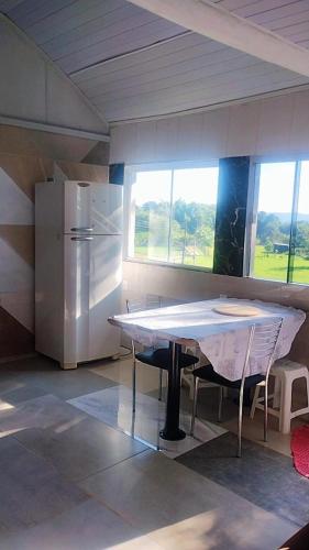 a kitchen with a table and a refrigerator at Chalé Paiano in Rio do Sul
