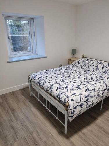 a bedroom with a bed in a room with a window at Tanerdy - Self Contained Apartment in Carmarthen