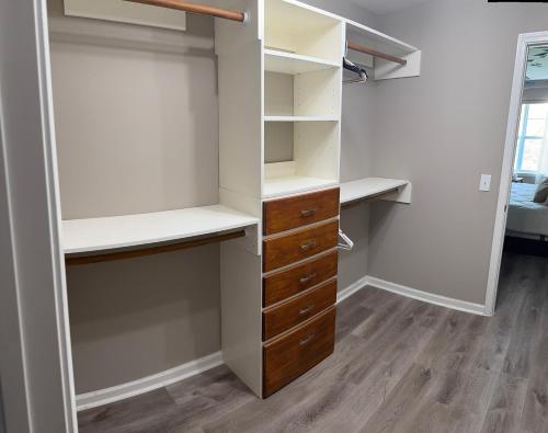 a walk in closet with white walls and wooden drawers at The home away from home in Greensboro