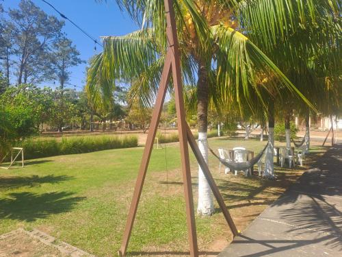 a swing set in a park with a palm tree at Sunset House Hostel in Liberia