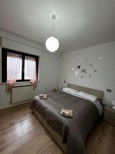 a bedroom with a large bed and a pendant light at La finestra su Assisi in Bastia Umbra