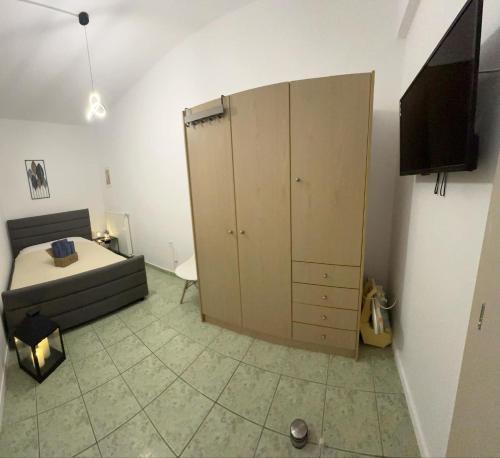 a bedroom with a bed and a large cabinet at Le Rocher 2 in Ermoupoli