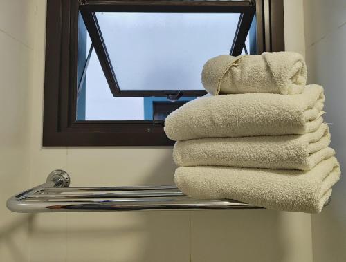 a stack of towels on a towel rack in a bathroom at Resort QSB - Um novo padrão de conforto e lazer no coração da cidade in Pirenópolis