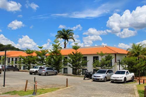 a parking lot with cars parked in front of a building at Resort QSB - Um novo padrão de conforto e lazer no coração da cidade in Pirenópolis