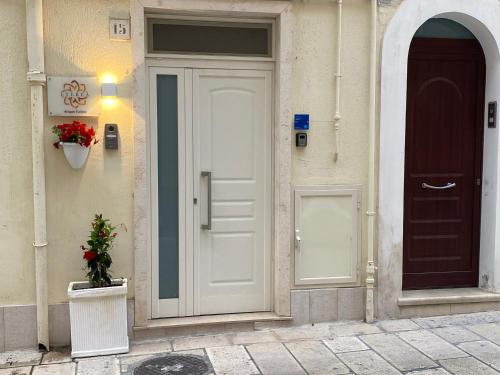 a white door of a building with a potted plant at Eterea Casa Vacanza in Brindisi
