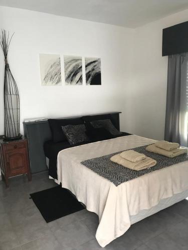 ein Schlafzimmer mit einem Bett mit zwei Handtüchern darauf in der Unterkunft Lo de Nina in Villa María