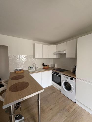 une cuisine avec des armoires blanches et un comptoir en bois dans l'établissement Charmant T2 rénové, à Lyon