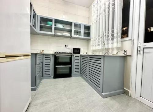 a large kitchen with white cabinets and appliances at Zanzibar stylish apartment in Zanzibar City