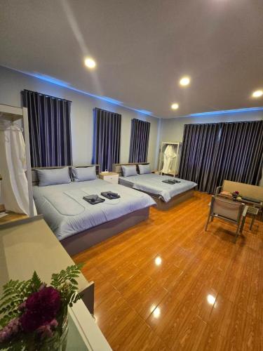 a large room with two beds and a table at Chaba 4 family in Nakhon Nayok
