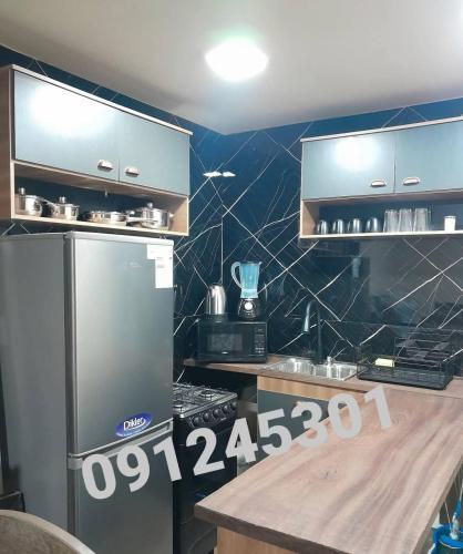 a kitchen with a stainless steel refrigerator and a counter at Cabañas CARPE DIEM Con o sin jacuzzi in Barra del Chuy