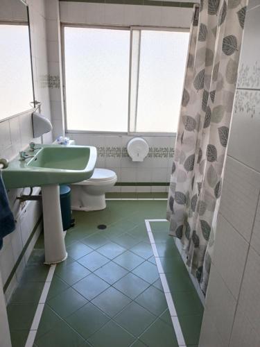 a bathroom with a green sink and a toilet at El Retorno a Viña in Viña del Mar