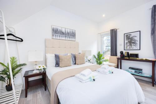 two beds in a room with white walls at Temple Chambers Aparthotel Central Croydon , Long Stays , Weekly & Monthly Offers , Contractors , Relocations , Leisure & Family Stays in Croydon