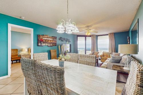 a dining room and living room with a table and chairs at Phoenix VI 206 in Orange Beach