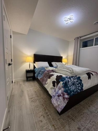 a bedroom with a bed with a comforter on it at Maxti Guest Suite, Northwest Calgary in YYC
