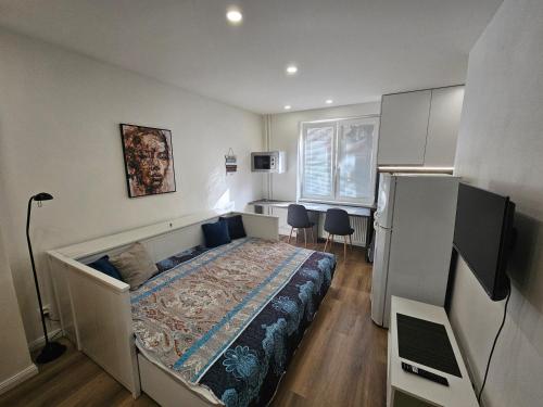 a small bedroom with a bed and a refrigerator at Central apartmán in Spišská Nová Ves