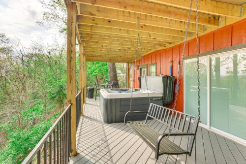 a porch with a swinging bench and a tub at Pet-Friendly Branson Area Home Hot Tub, Game Room in Reeds Spring