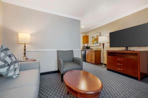 a hotel room with a couch and a table and a tv at Best Western Plus Marina Shores Hotel in Dana Point