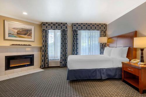 a hotel room with a bed and a fireplace at Best Western Plus Marina Shores Hotel in Dana Point