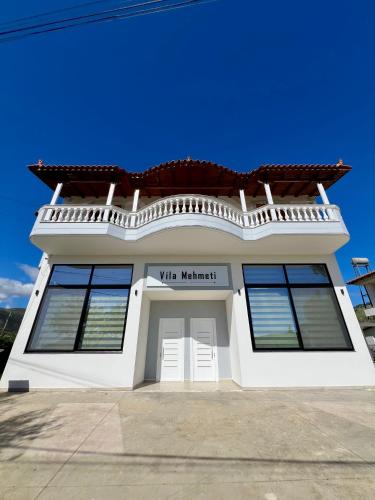 a white house with a white door and windows at Vila Mehmeti in Delvinë