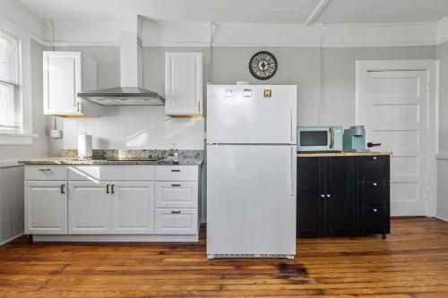 a white kitchen with a refrigerator and a microwave at Luxury 1 Bed Downtown Columbia Upstairs in Columbia