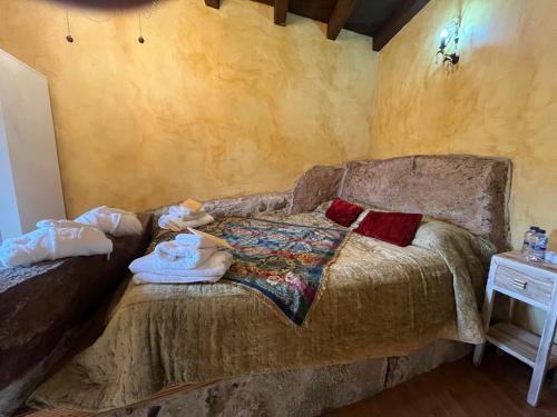 a bedroom with a couch with towels on it at Cabachuelas I casas rurales in San Miguel de Valero