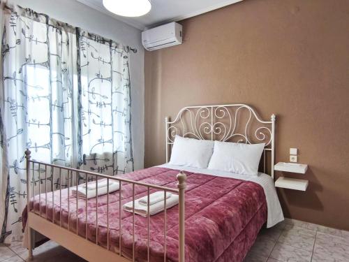 a bedroom with a bed with a pink bedspread at Ahelia in Kalabaka