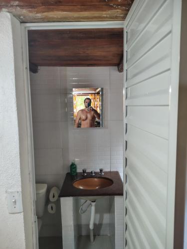 un homme prenant une photo d'une salle de bains avec lavabo dans l'établissement Pouso da Cajaíba - Chalé Pedaço de Céu, à Parati