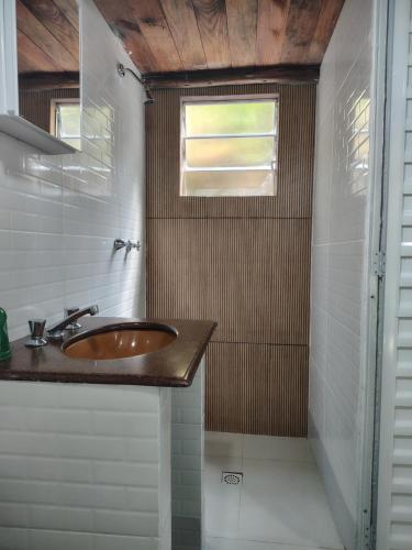 a bathroom with a sink and a window at Pouso da Cajaíba - Chalé Pedaço de Céu in Paraty