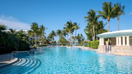 a swimming pool at a resort with palm trees at 809 Mariners Club in Key Largo