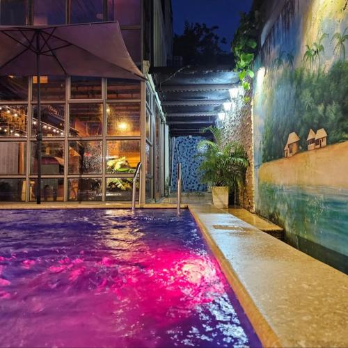 a swimming pool with pink water in a building at Alta vista Turbaco in Cartagena de Indias