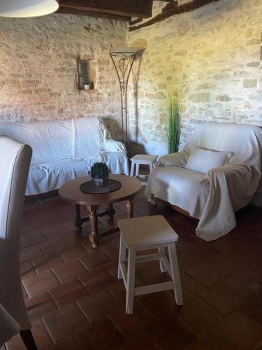 un salon avec des canapés blancs et une table dans l'établissement Maison de vacances, à Nadaillac