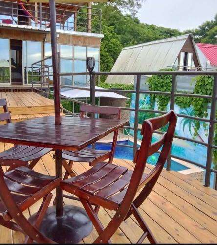 a wooden table and chairs on a deck with a pool at Alta vista Turbaco in Cartagena de Indias
