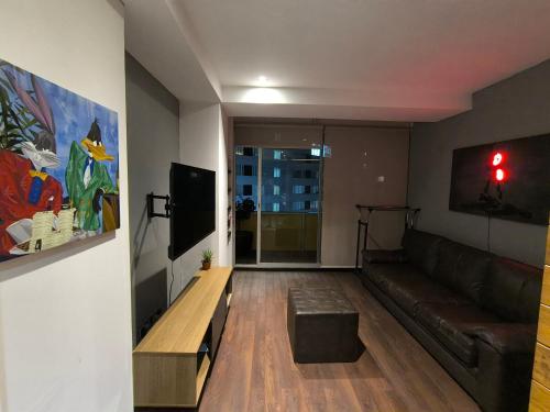 a living room with a couch and a tv at Cómoda habitación en Santa fe in Mexico City