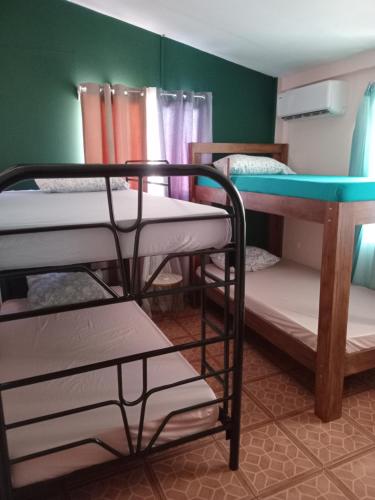 a room with three bunk beds and a table at Sunset House Hostel in Liberia