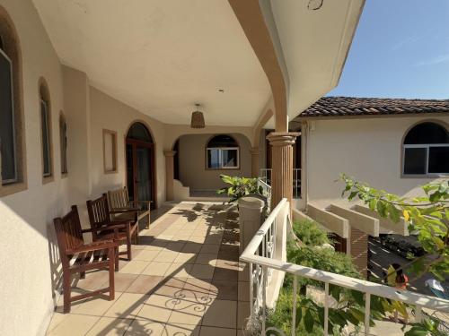 a porch of a house with chairs and tables at Hotel San Juan in Puerto Escondido