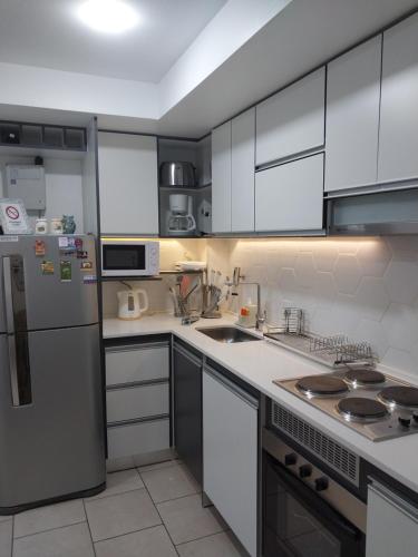 a kitchen with white cabinets and a stainless steel refrigerator at Ushuaia Extremo Sur in Ushuaia