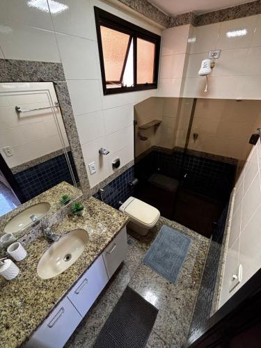 a bathroom with a sink and a toilet at Apartamento Espaçoso com Vista Fabulosa para o Mar in Guarapari