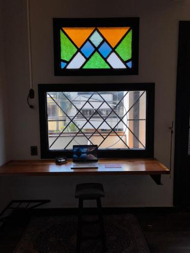a desk with a stained glass window in a room at Departamento divino a media cuadra del Faro de la Costanera in Vuelta del Paraguayo