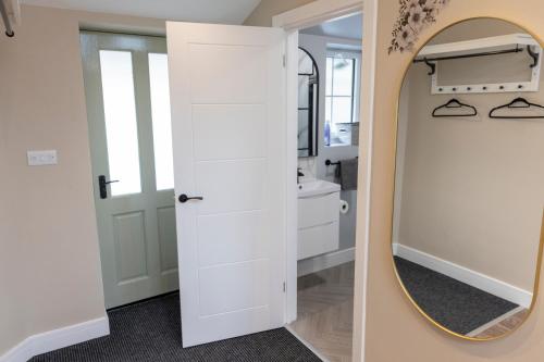 a bathroom with a mirror and a white door at The Bear inn in Llantrisant