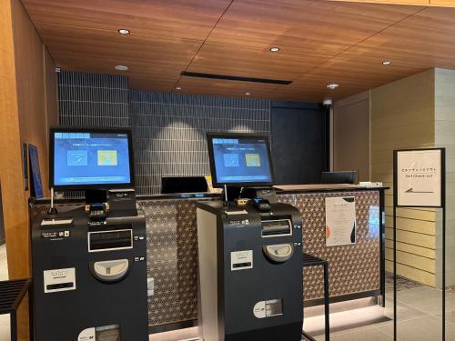 a store with two machines and two computer monitors at Shizutetsu Hotel Prezio Kyoto Karasumaoike in Kyoto