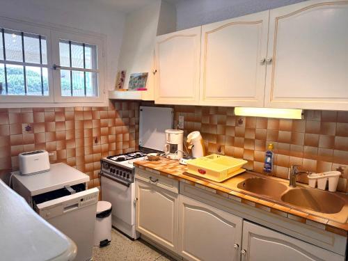 une cuisine avec un évier et une cuisinière dans l'établissement Appartement T3 au calme et proche des plages, à Cavalaire-sur-Mer